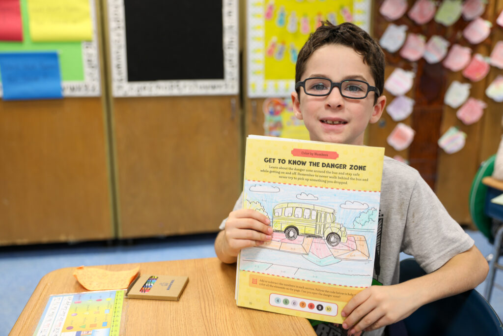 Student holding up a Buspatrol safety guide.