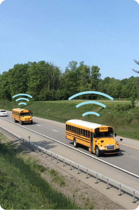 Two Busses traveling on the highway with WiFi signal icons over them.