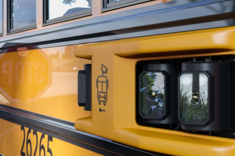 Side of school bus with camera.