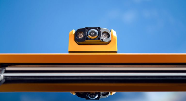 View of a BusPatrol safety camera on the school bus roof, above a window