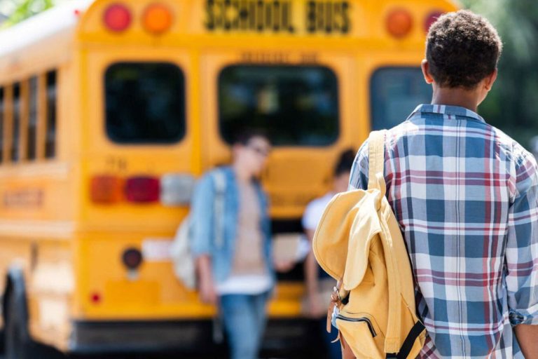 Student walking in back of bus.